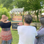 Convives qui jouent au jeu du tir aux canards un jeu type fête foraine lors d'une animation pour un séminaire d'entreprise à Grenoble